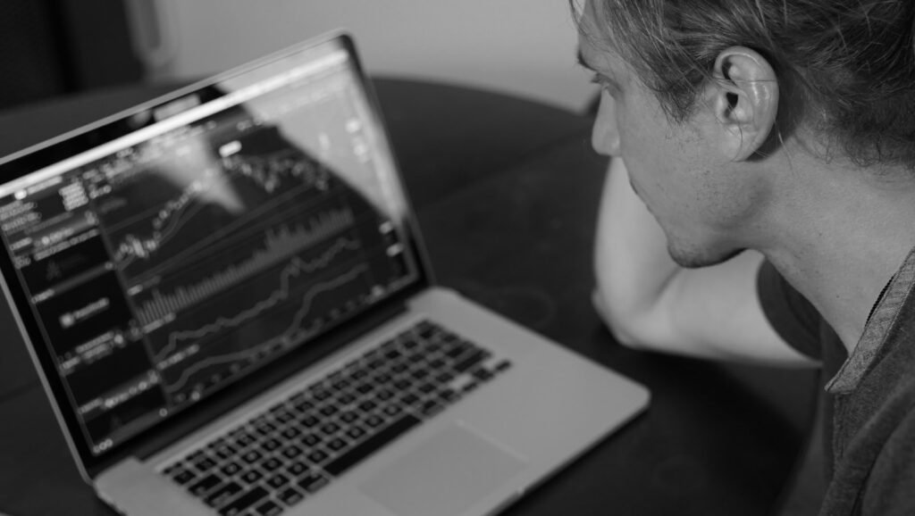 grayscale photo of man looking at macbook pro